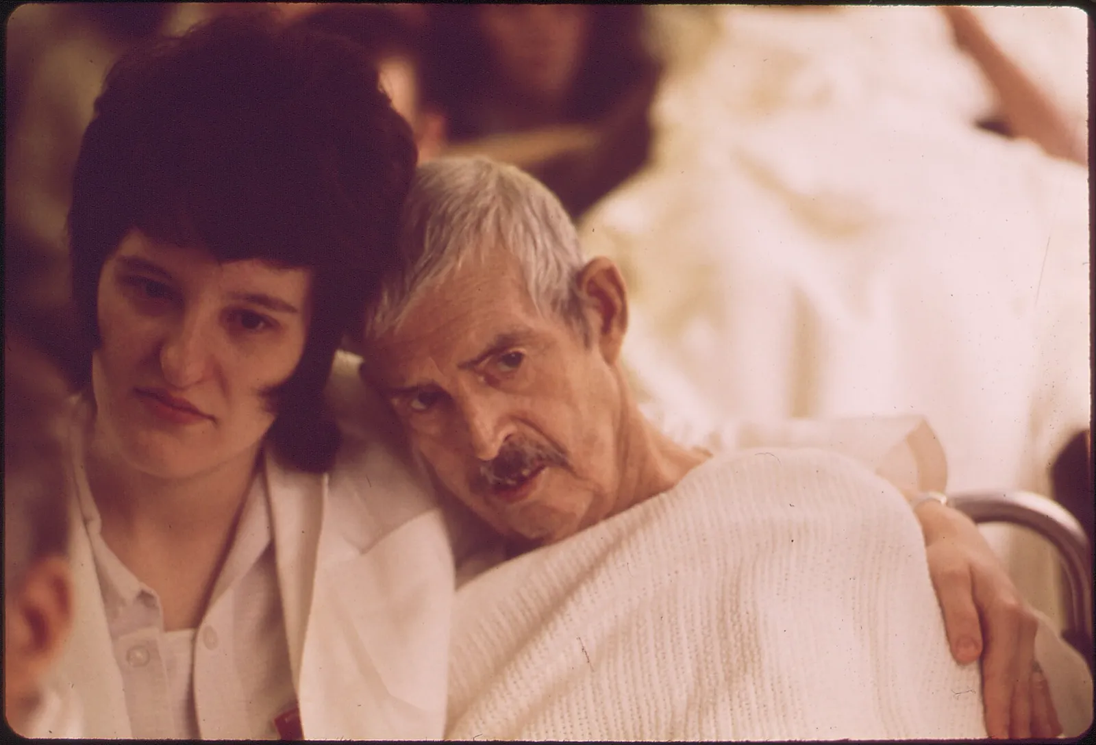 A nurse helps an elderly patient.
