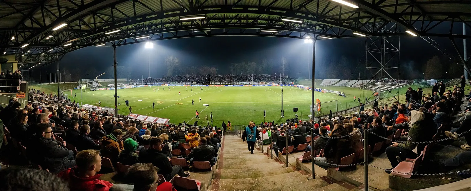A football match underway in a packed stadium.