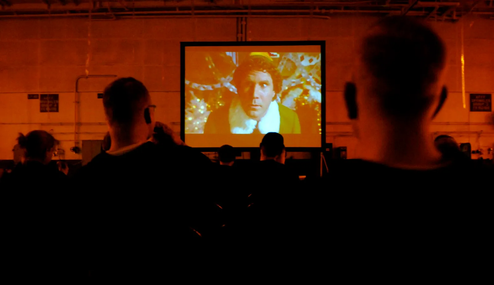 An audience watching a film in a darkened theater.
