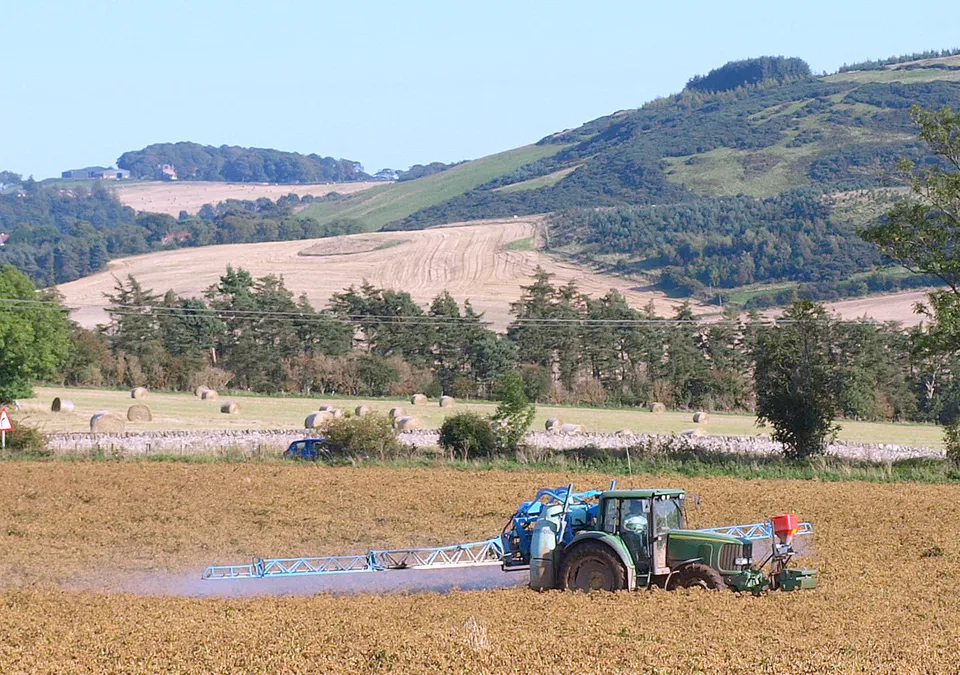 A tractor sprays a field.