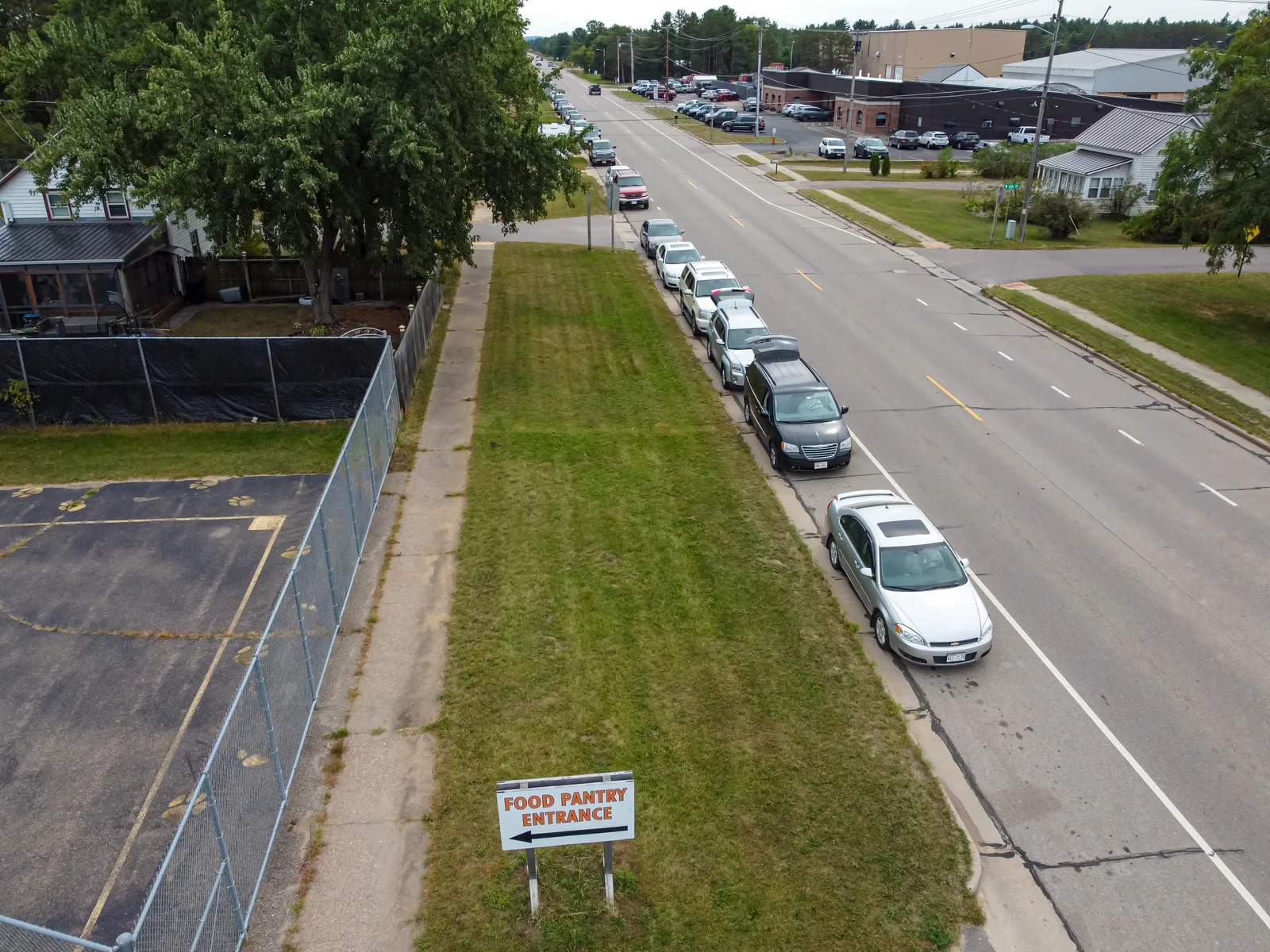 Cars line up at a food pantry distribution.