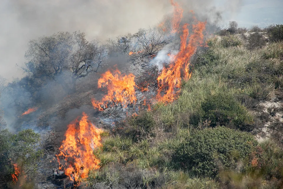 A wildfire crosses a Southern California hillside
