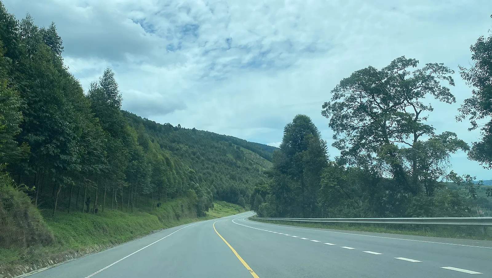 A hilly road winding through the Ugandan countryside