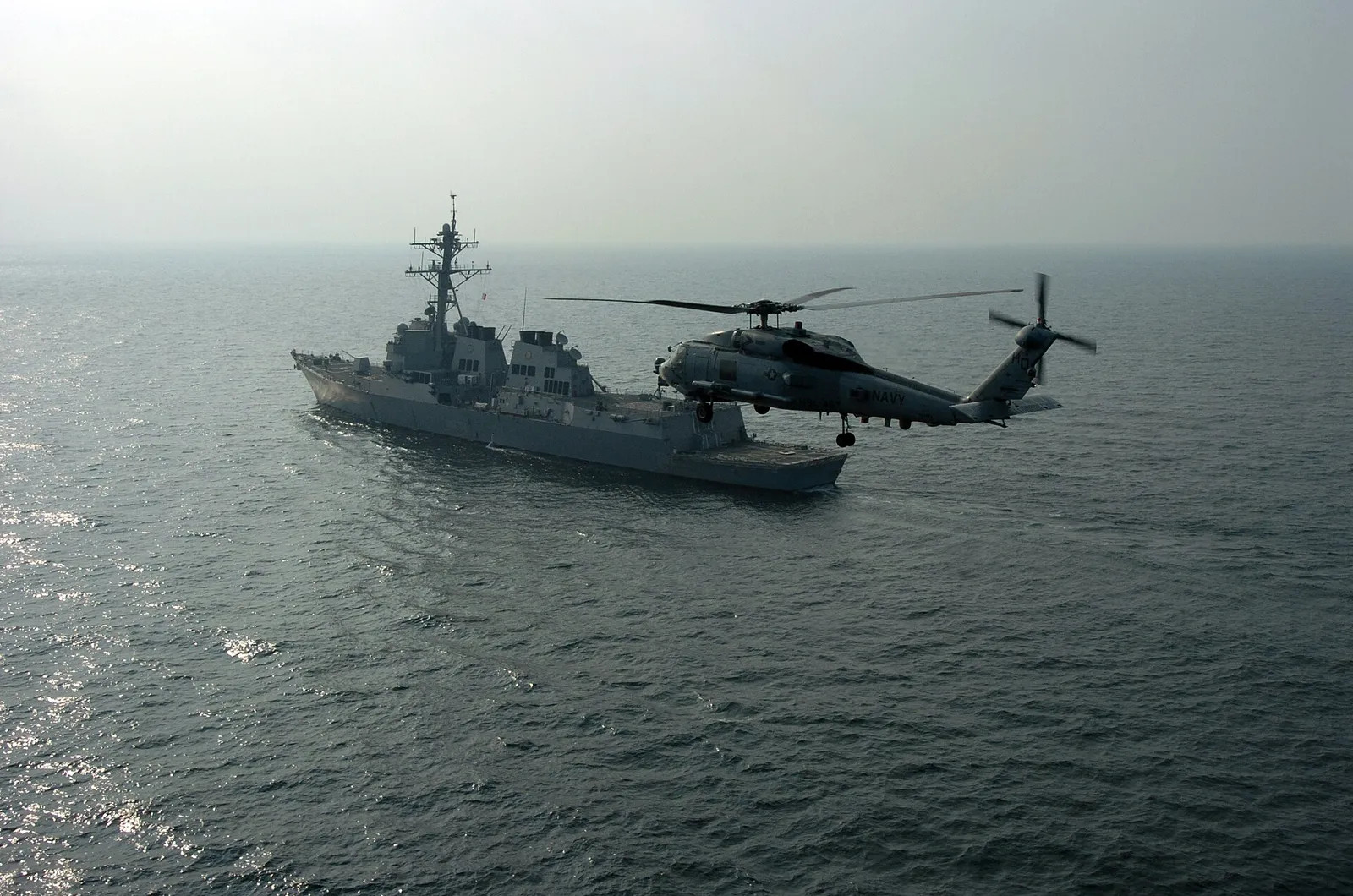 A US Navy destroyer and helicopter patrolling the northern Persian Gulf