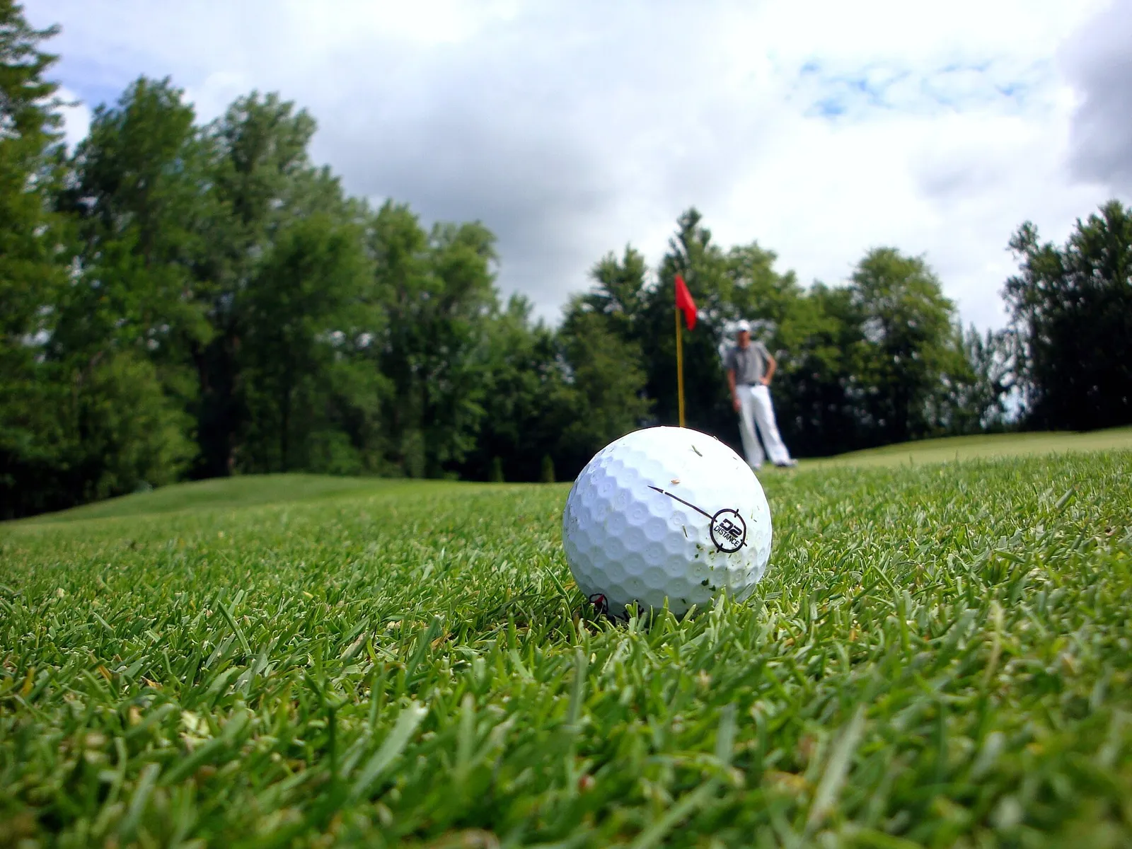 A golf ball beside the hole on a putting green
