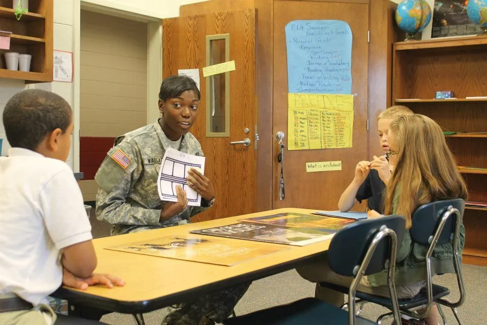 Volunteers help students with schoolwork in a classroom.