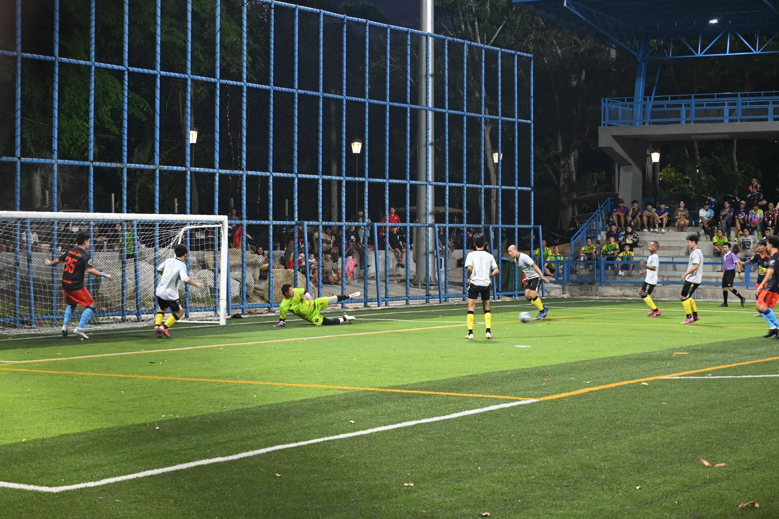 A goalkeeper dives to make a save during a soccer match.
