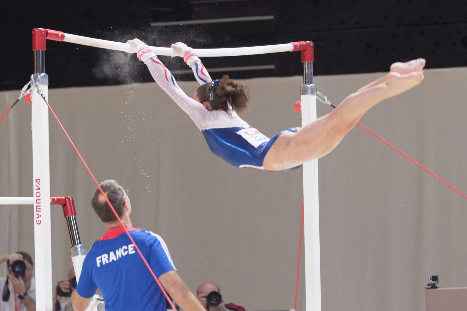 A gymnast competing on the uneven bars