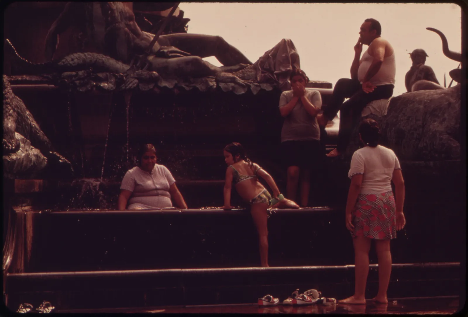 People cool off in fountains during a heat wave.