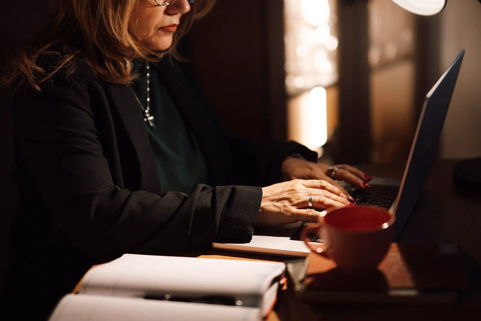 A middle-aged businesswoman working on a laptop.
