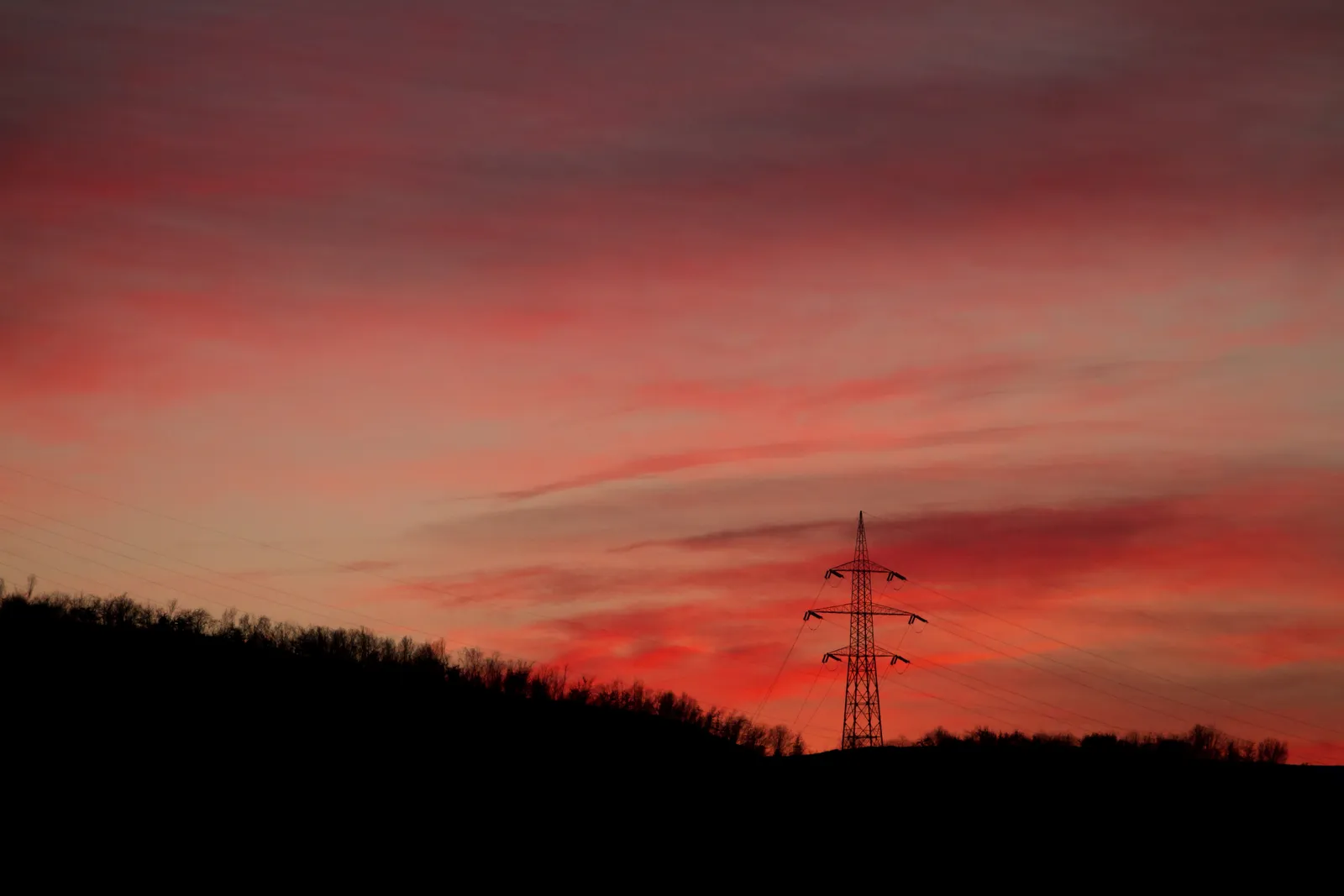 An electricity transmission tower at dusk.