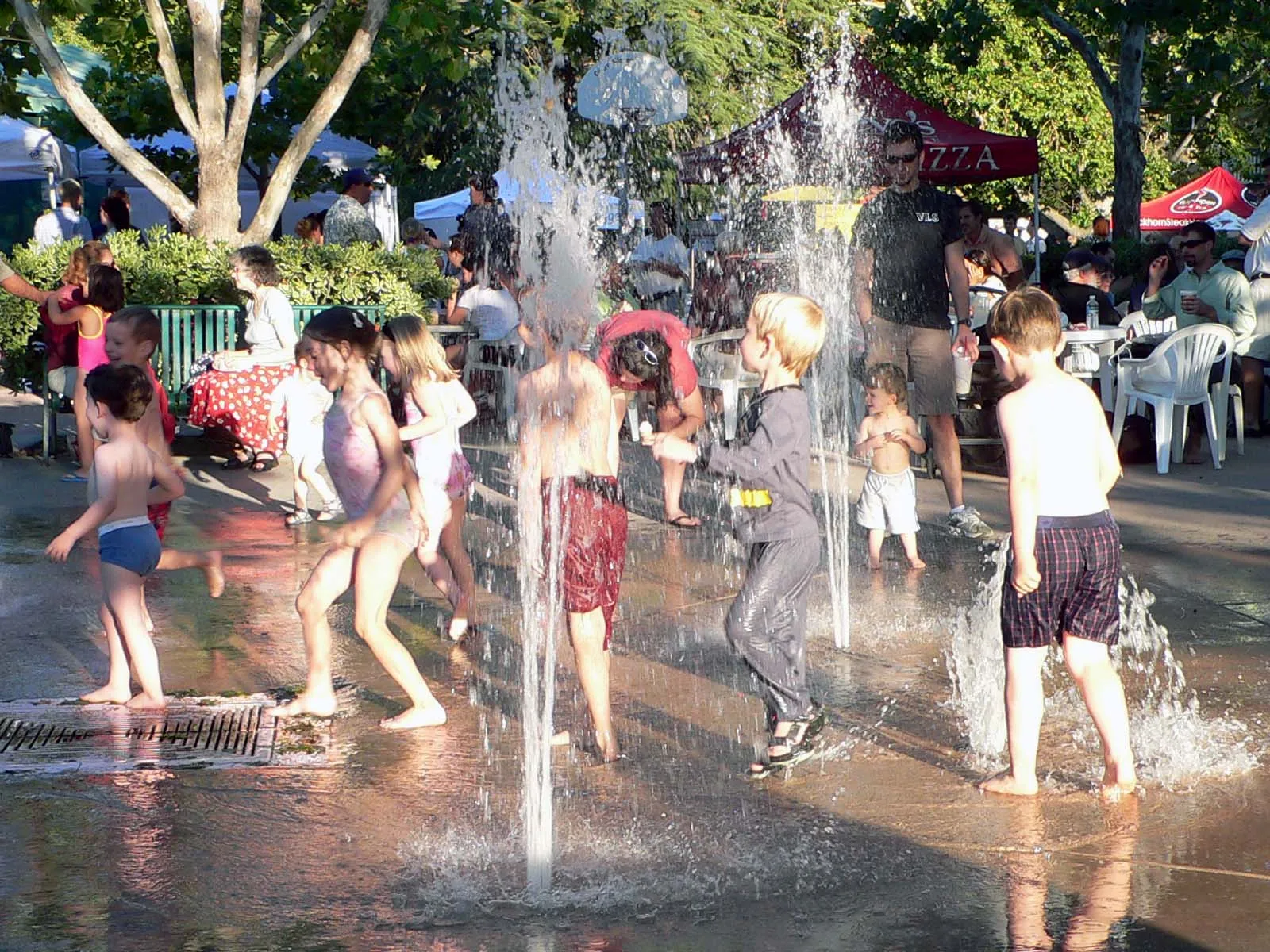 People cool off in a fountain during a summer heat wave.