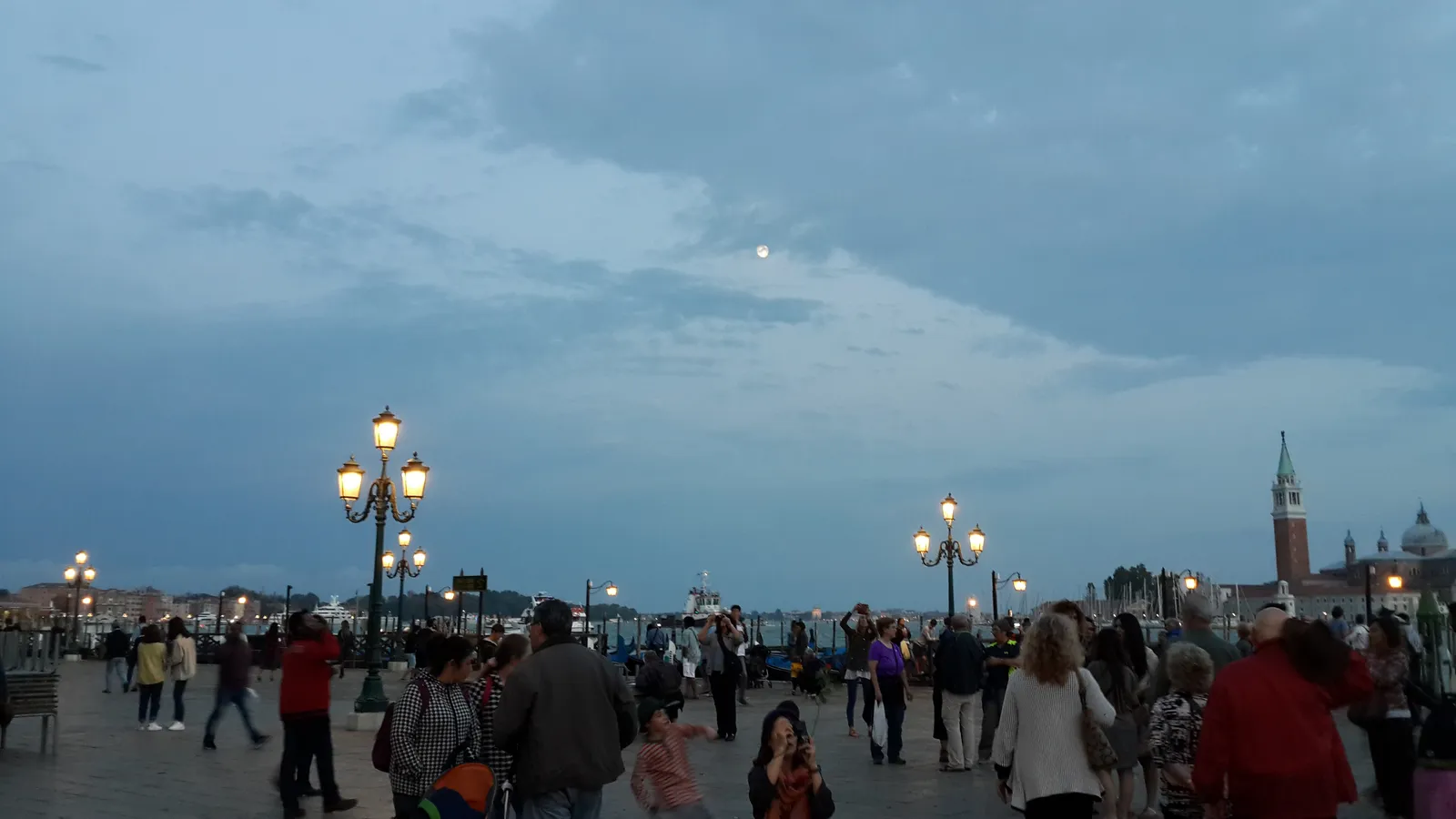 A full moon rising over a city.