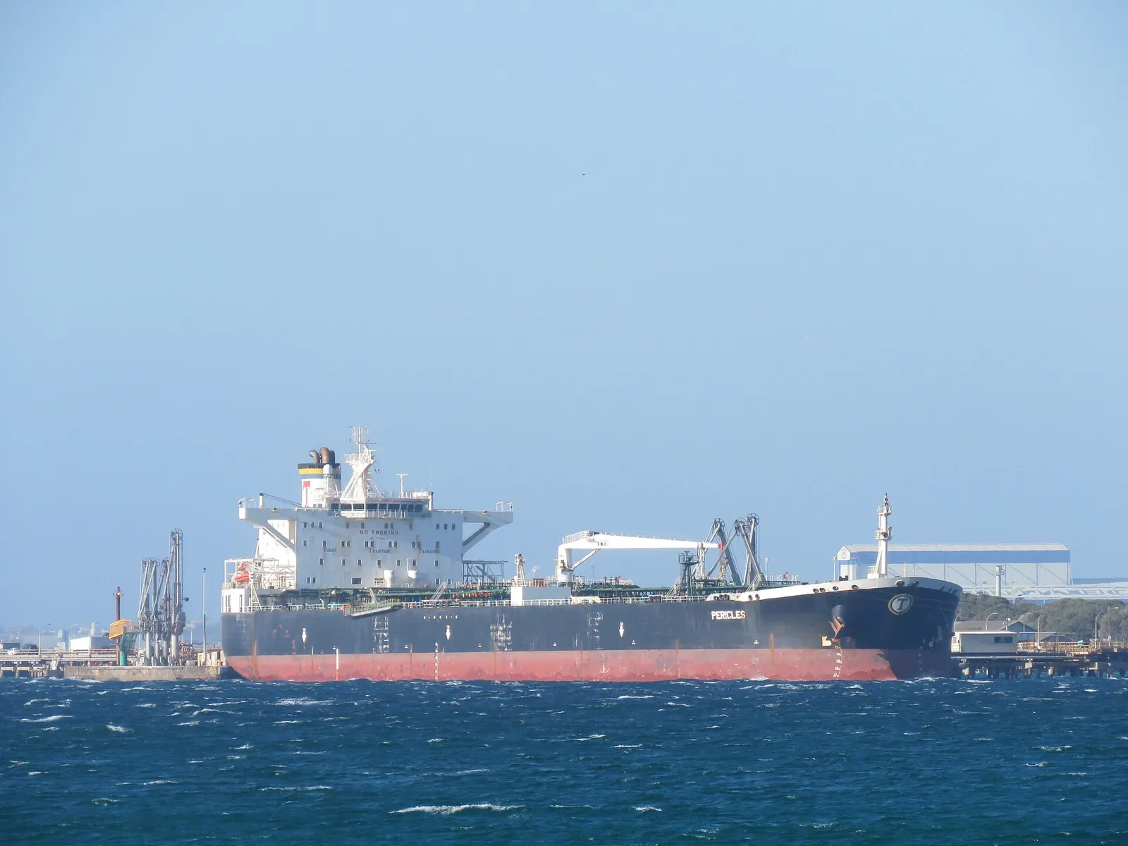 A crude oil tanker moored at a refinery jetty